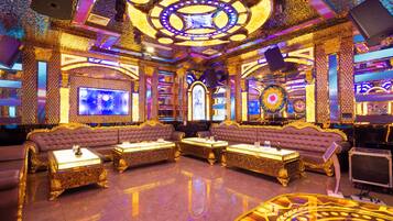 A luxurious room with a large seating area, a television, and a decorative ceiling.
