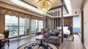 Une chambre d’hôtel luxueuse, dotée d’un grand tapis rond, d’un mobilier élégant et offrant une vue sur le paysage urbain.