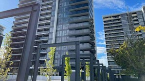 Un moderno edificio de gran altura con varios balcones y cielo despejado.