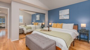 A bedroom with two beds, a large mirror, and a view of the beach. - Super Cute Top Location, Fast WiFi (Reno)