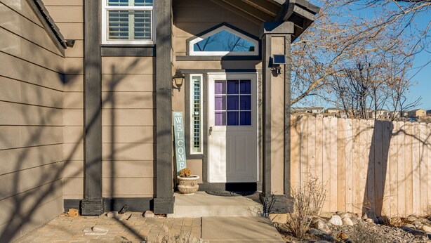 A house with a front porch, a welcome sign, and a wooden fence. - Super Cute Top Location, Fast WiFi (Reno)