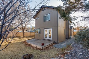 A two-story house with a deck, a garage, and a fenced yard.