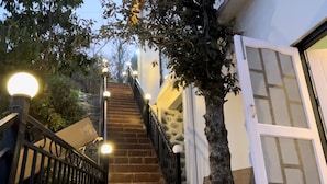 A staircase with a black railing and multiple light fixtures. - Ramshila Cottage (Nainital)