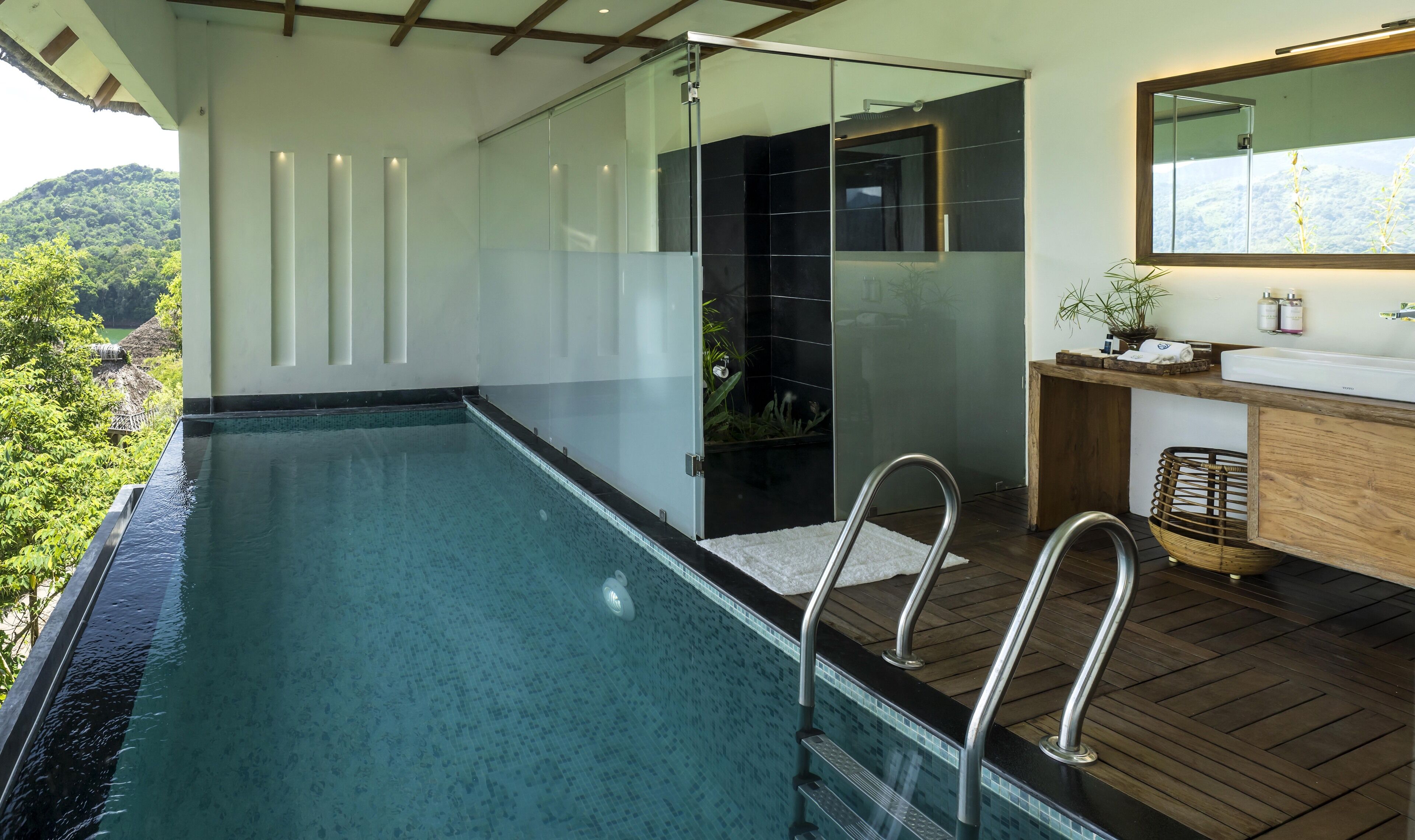 A modern bathroom with a glass shower enclosure, a wooden vanity, and a large mirror.