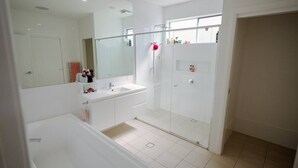 A modern bathroom with a glass shower enclosure, a large mirror, and a white sink. - Spectacular water views & entertaining spaces (Corlette)