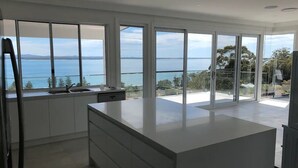A modern kitchen with large windows offering a view of the sea. - Spectacular water views & entertaining spaces (Corlette)