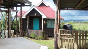 Cozy cabin with a single door and window, set amidst a rural landscape.