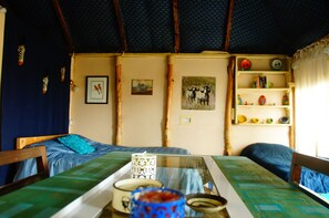 Relax in a traditionally designed room with a comfortable bed, wooden chair, and decorative artwork.
