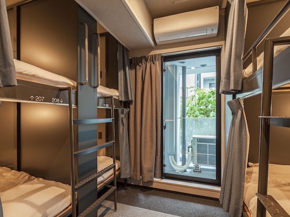 A compact hotel room with bunk beds, a sliding door to a balcony, and an air conditioning unit. - Hotel Plus Hostel TOKYO AKIHABARA (Tokyo)