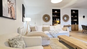 Una sala de estar moderna con un sofá, una mesa de centro y un comedor con una mesa y sillas.