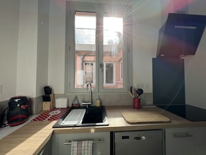A kitchen with a window, a Bosch coffee maker, a sink, a cutting board, and a dishwasher. - Au coeur de ville, bel appt 3 chambres de 105m2. (Cauterets)