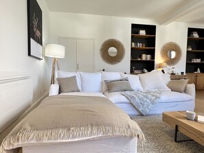 A modern bedroom with a large bed, a sofa, and two bookshelves. - Au coeur de ville, bel appt 3 chambres de 105m2. (Cauterets)