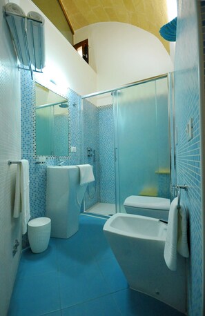 Een badkamer met een glazen douchecabine, een wit toilet en een bad.