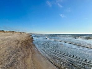 A beach with clear water and a sandy shore.