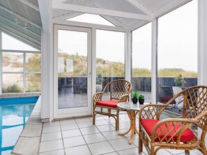 A covered patio area with a pool, wicker furniture, and a view of the landscape. - Seaside Wellness Retreat - By Traum Ferienwohnungen (Saltum)