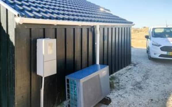 A building with a sloped roof, a utility box, and an air conditioning unit. - Seaside Wellness Retreat - By Traum Ferienwohnungen (Saltum)