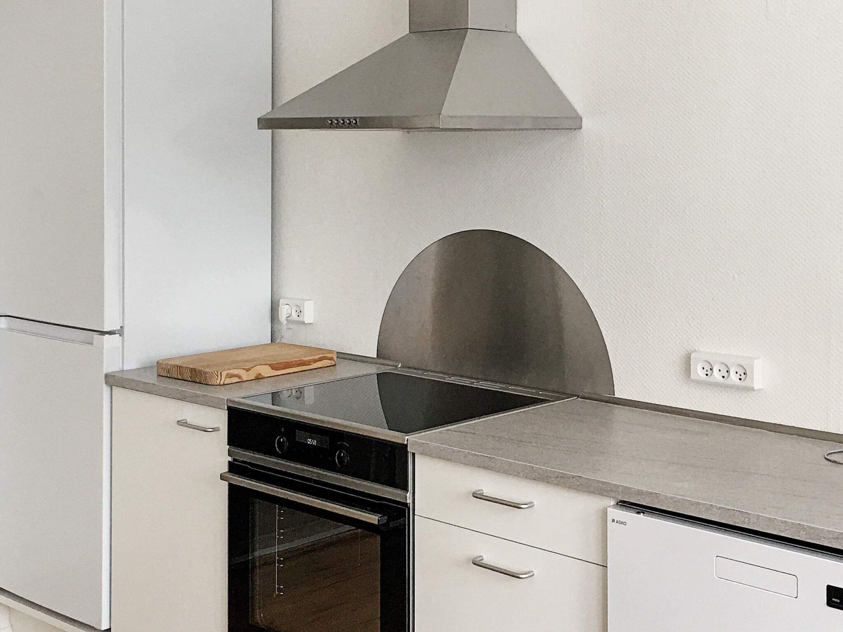 A kitchen with a stainless steel range hood, a built-in oven, and a dishwasher.