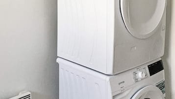 A stacked washer and dryer unit in a laundry room.
