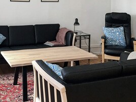 Una sala de estar con un sofá, una mesa de centro y un sillón.