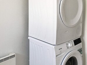 A stacked washer and dryer unit in a laundry room.