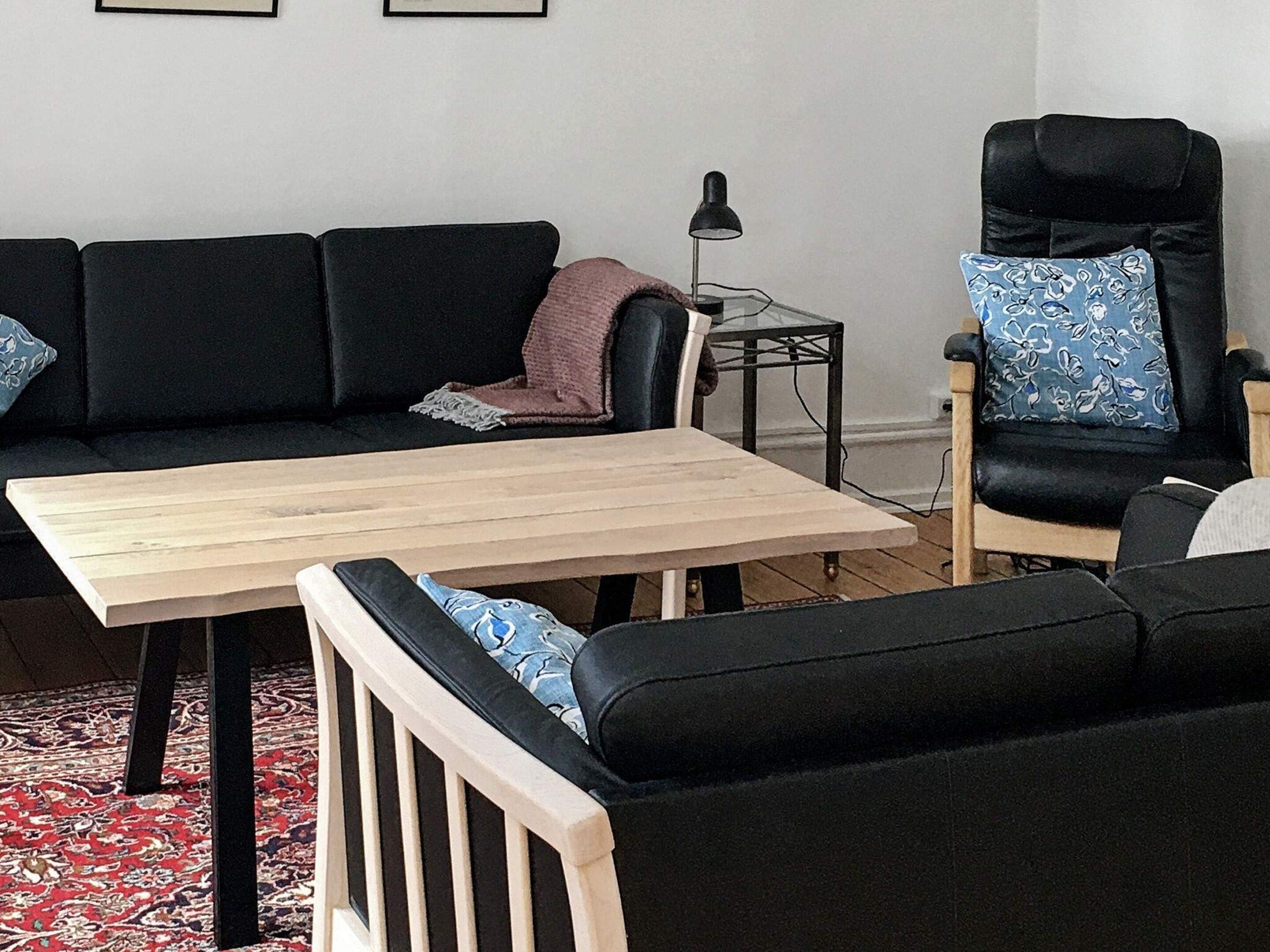 A living room with a sofa set, a coffee table, and a chair.