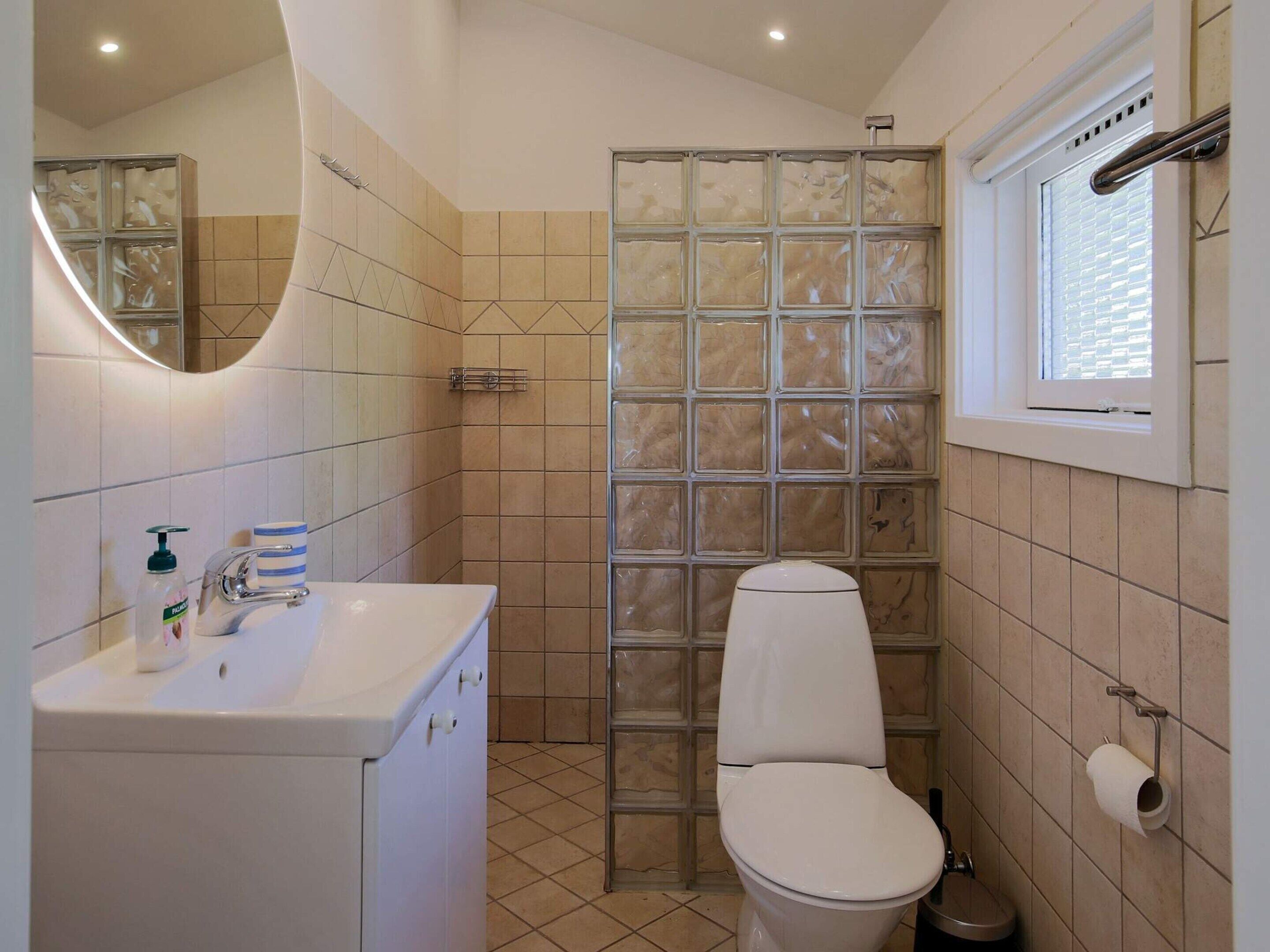 A bathroom with a white sink, a toilet, and a shower enclosure with a glass door.