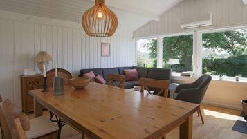 Comedor con mesa de madera, sillas y lámpara colgante.