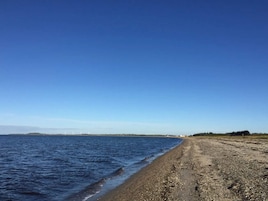 Una playa con cielo despejado y mar tranquilo.