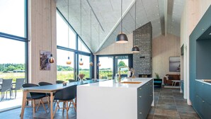 A modern kitchen with a large island, large windows, and a view of the outdoors. - 12 Person Holiday Home in Haderslev (Haderslev)