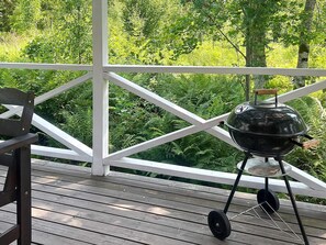 A wooden deck with a barbecue grill and a bench. - 4 Person Holiday Home in Braas (Braås)