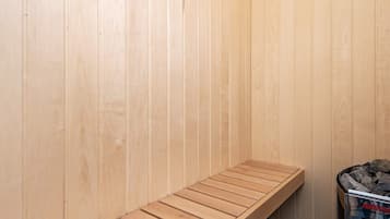 Een sauna met houten banken en een zichtbare prullenbak.