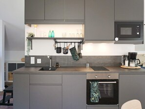 A modern kitchen with a built-in oven, a microwave, and a sink. - 4 Person Holiday Home in Rimbo (Rånäs)