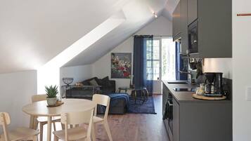 A modern loft apartment with a dining area, kitchen, and living space.