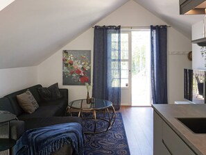 A modern living room with a sofa, a glass coffee table, and a painting on the wall. - 4 Person Holiday Home in Rimbo (Rånäs)