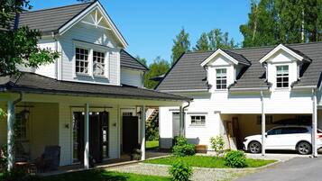 A two-story house with a covered porch, a garage, and a car parked in the driveway.