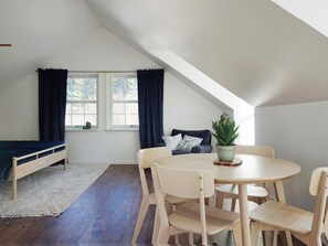 A room with a loft bed, a dining table with chairs, a potted plant, and a window with curtains. - 4 Person Holiday Home in Rimbo (Rånäs)
