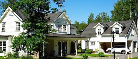 Et toetagers hus med veranda, garage og indkørsel.
