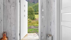 Une pièce dotée d’une porte en bois donnant sur un balcon avec vue sur la montagne.