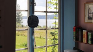 A kitchen with a view of a lake, a coffee maker, and a shelf with containers. - 6 Person Holiday Home in Ostra Antervik-by Traum (Östra Ämtervik)
