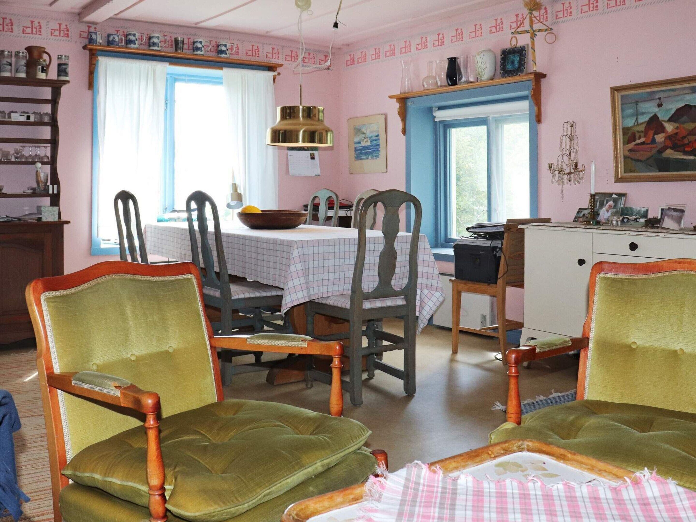 A dining room with a table set for four, surrounded by wooden chairs with cushioned seats.