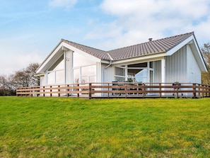 A modern house with a large deck, a covered outdoor area, and a spacious lawn. - 4 Star Holiday Home in Nordborg (Nordborg)
