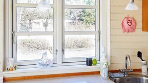 A kitchen with a window, a sink, and a pig-shaped decoration on the wall. - 4 Person Holiday Home in Store Fuglede (Store Fuglede)