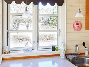 A kitchen with a window, a sink, and a pig-shaped decoration on the wall. - 4 Person Holiday Home in Store Fuglede (Store Fuglede)