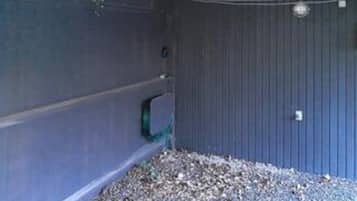 A room with a blue wall, a small window, and a pile of gravel on the floor.