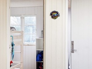 A room with a bunk bed, a window, a door, and a shelf with bags. - 4 Person Holiday Home in Store Fuglede (Store Fuglede)