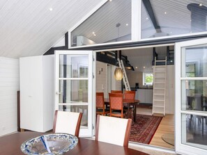 A dining area with a table, chairs, and a glass bowl. There is a staircase leading to an upper level. - 5 Star Holiday Home in Haderslev (Haderslev)