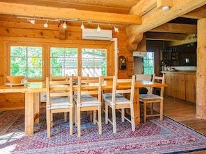 A wooden cabin interior with a dining area, kitchen, and large windows. - 8 Person Holiday Home in Ebeltoft (Ebeltoft)
