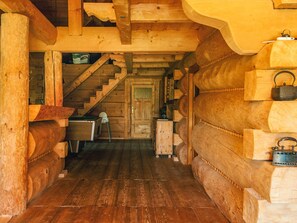 A wooden log cabin interior with a staircase leading to a door, wooden walls, and a small table with a chair. - 8 Person Holiday Home in Ebeltoft (Ebeltoft)
