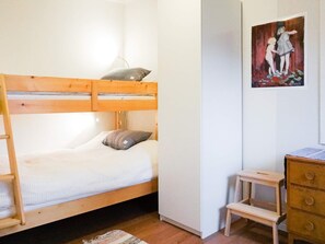 A bunk bed with a pillow, a small wooden stool, and a dresser. - 3 Person Holiday Home in Henan (Henån)