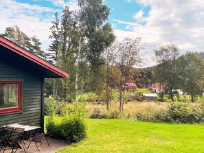 A house with a red roof and a small patio with a table and chairs. - 3 Person Holiday Home in Henan (Henån)